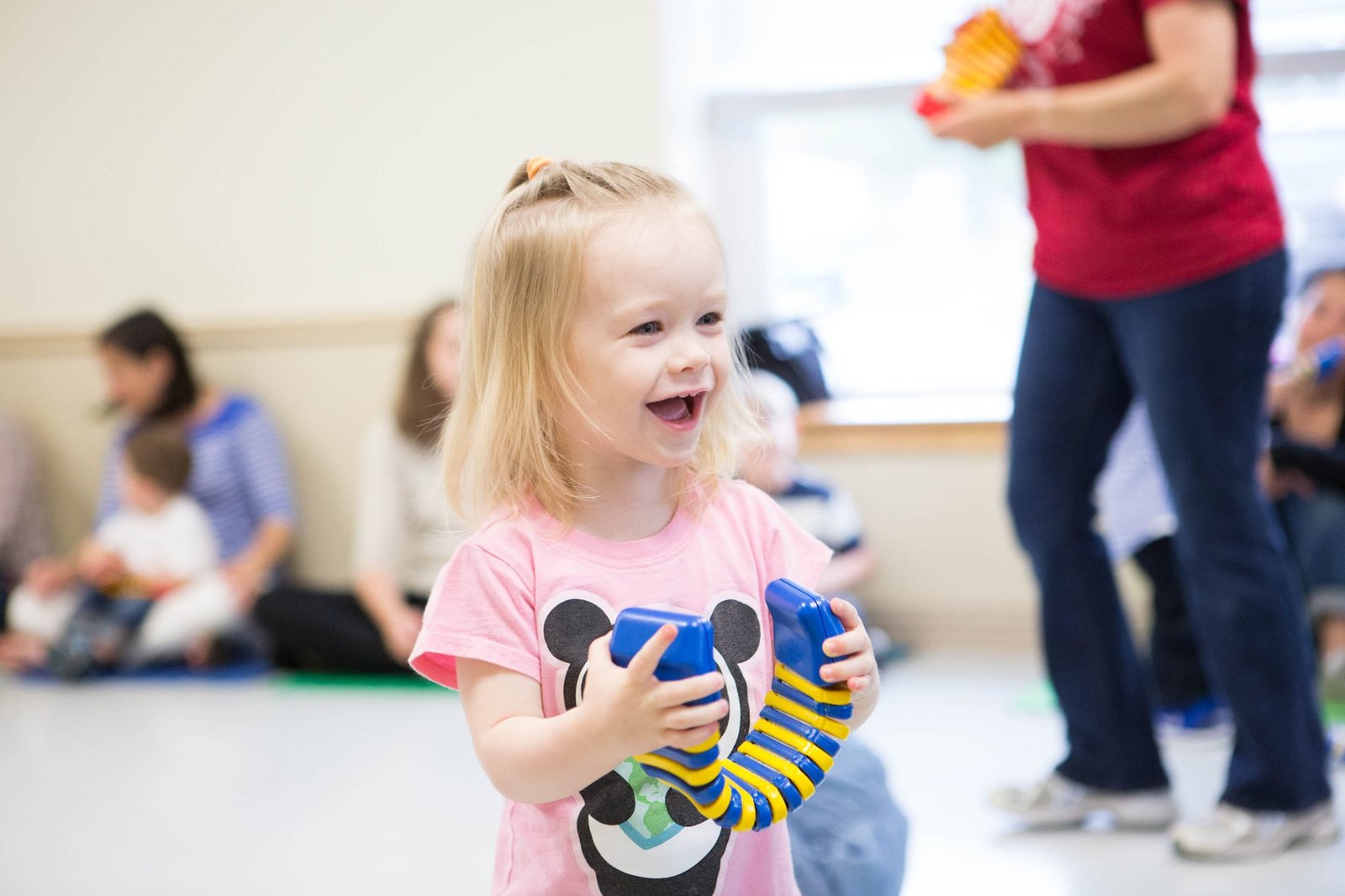 Child smiling while playing a musical instrument in class